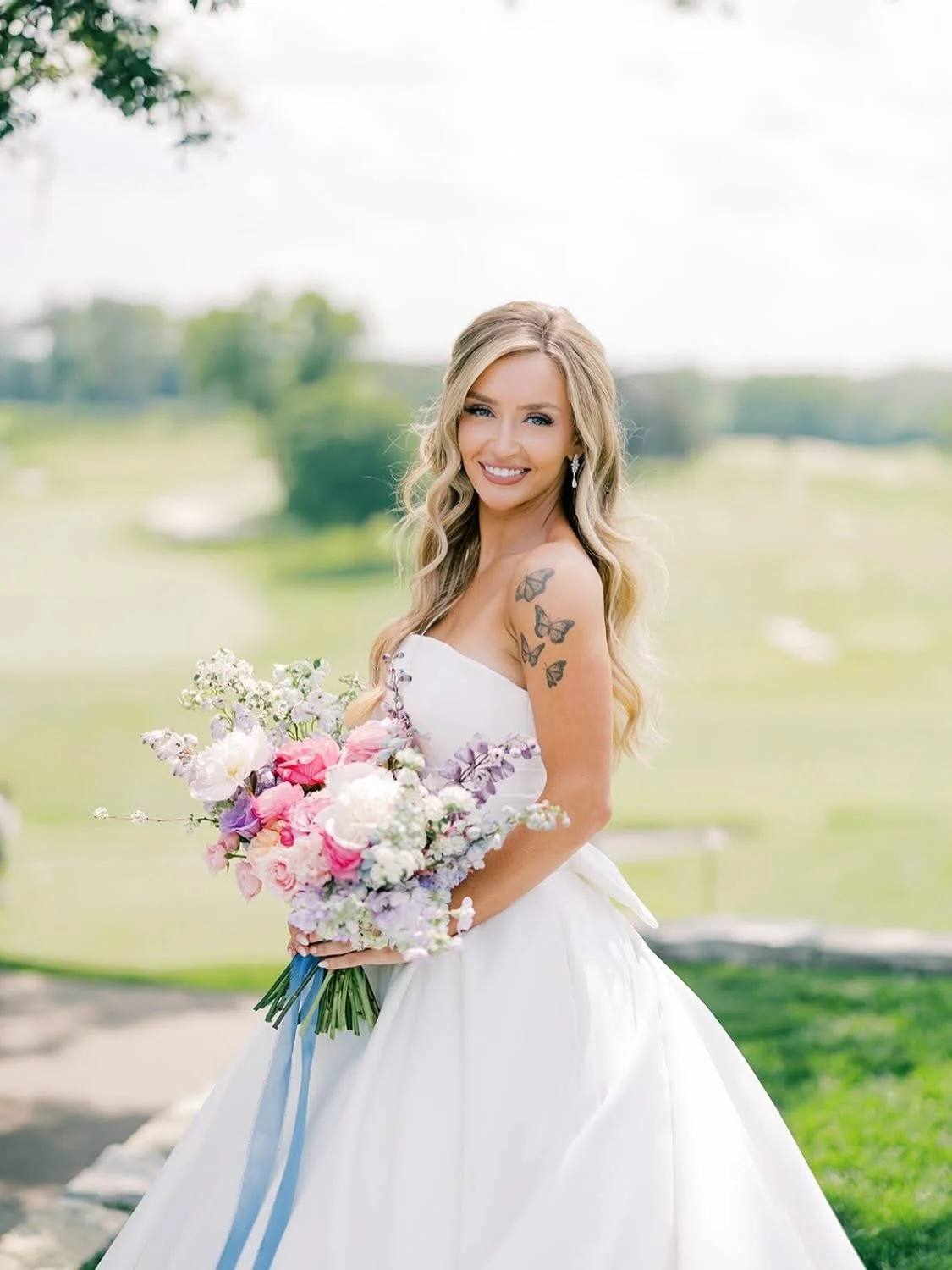 Taylor, founder of The Spread, smiling and holding a bouquet